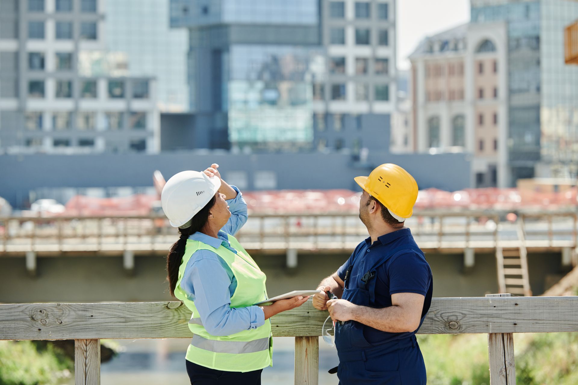 Engenheiros com capacete analisando o andamento de uma obra